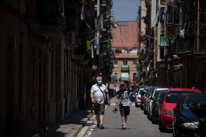 BARCELONA. Dos personas transitan por una calle, ayer, tras el pedido de las autoridades de no salir de casa.
