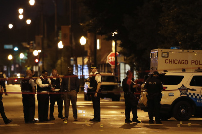 Policías investigan la escena de un tiroteo frente a Rhodes Funeral Service en Chicago.