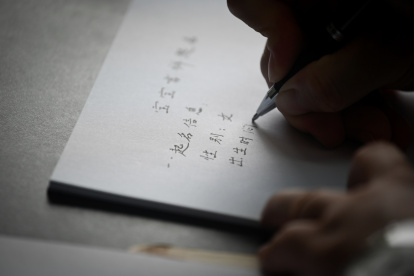 Yang Yiren, experto en nombres chinos, dando un nombre a la hija recién nacida de un hombre.