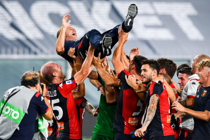 Los jugadores del Génova levantan eufóricos a su técnico, Davide Nicola, tras asegurar su permanencia en la máxima categoría del fútbol italiano.