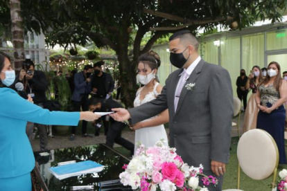 Sofía Cruz, jefa de Matrimonio de la corporación Registro Civil, entrega el certificado de que Daniel Toaza y Nicolle Torres, en una boda a domicilio que se dio en julio.