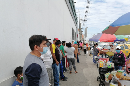 En Valdivia, al sur de Guayaquil, las personas hacen fila sin mantener el distanciamiento físico.