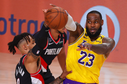 LeBron James (23) de Los Angeles Lakers disputa la pelota ante Gary Trent Jr. (2) de los Portland Trail Blazers.