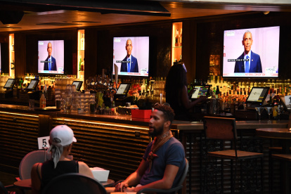 Former US President Barack Obama is seen on television screens as he speaks during the third day of the Democratic National Convention, being held virtually amid the novel coronavirus pandemic, at The Abbey bar and restaurant in West Hollywood, California, August 19, 2020. (Photo by Robyn Beck / AFP)