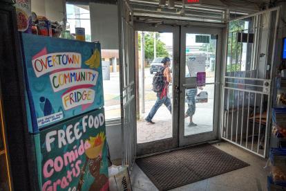 MIAMI. Dos personas caminan frente a Harba Food Store, donde está instalada una de las neveras comunitarias, en Overtown.