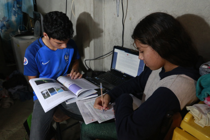 En una vivienda de la cooperativa Sergio Toral, dos hermanos comparten una computadora para recibir las clases no presenciales del sistema educativo público.