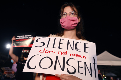 An Israeli woman wearing a protective mask due to the COVID-19 pandemic, holds a placard as she takes part in a demonstration in Tel Aviv on August 23, 2020, to denounce sexual violence against women following the alleged gang-rape of a 16-year-old girl in a Red Sea resort. - Police said 11 suspects, including nine minors and a woman said to be the manager of the hotel in which the alleged rape took place, had been arrested in connection with the affair so far as part of an "ongoing investigation". (Photo by JACK GUEZ / AFP)