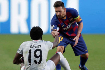 Lionel Messi (d) y Alphonso Davies (i) forman parte del equipo de la temporada de la Champions League.