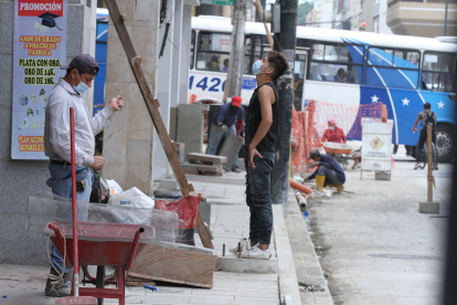 Un grupo de albañiles labora en una calle del centro de Guayaquil protegidos con mascarillas, como parte de las medidas para evitar contagios de Covid-19 en el trabajo.