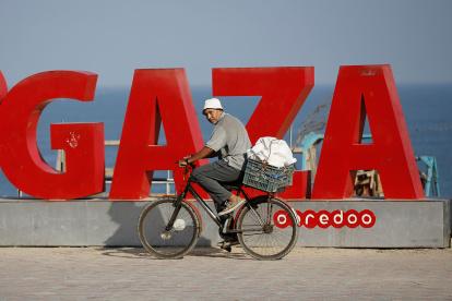 Gaza. Un palestino se traslada en bicicleta cerca de la playa.