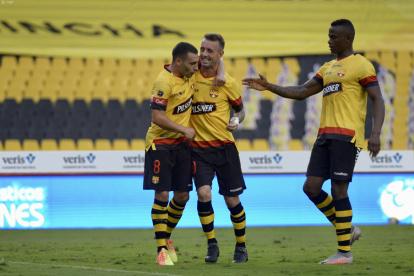 Damián Díaz (c), es felicitado por Emmanuel Martínez (i) luego de marcar el primer tanto de Barcelona.