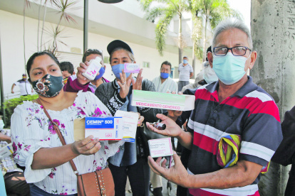 Reclamo. Un grupo de pacientes del IESS muestran las cajas vacías de las medicinas que no reciben.