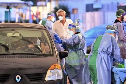 Un médico realiza pruebas de hisopado a los pasajeros de barcos que llegan de Cerdeña, en el puerto de Civitavecchia, cerca de Roma, capital de Italia.