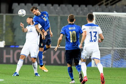 Edin Dzeko (i) pelea una pelota con el defensor Francesco Acerbi (c).