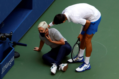 El tenista serbio Novak Djokovic intenta ayudar a una juez de línea después de golpearla con una bola en la garganta.