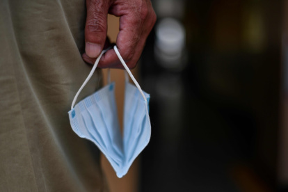 WUHAN. Un hombre sostiene una mascarilla en un ferry mientras cruza el río Yangtze.