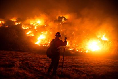 A firefighter works at the scene of the Bobcat Fire burning on hillsides near Monrovia Canyon Park in Monrovia, California on September 15, 2020. - A major fire that has been raging outside Los Angeles for more than a week threatened to engulf a historic observatory and billion-dollar broadcast towers on September 15 as firefighters struggled to contain the flames. The so-called Bobcat Fire was within 500 feet (150 meters) from the 116-year-old Mt. Wilson Observatory, the US Forest Service said in a tweet, while fire officials said crews were in place "ready to receive the fire." (Photo by RINGO CHIU / AFP)
