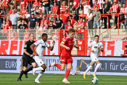 Carlos Gruezo (i), volante ecuatoriano del Augsburgo, va por la marca de un jugador del Unión Berlín.