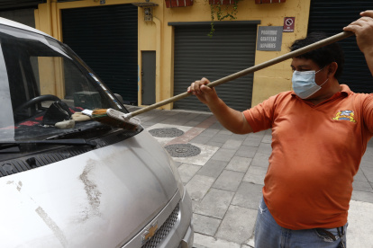 Un ciudadano de Guayaquil retira las cenizas del volcán en un barrio de Guayaquil.