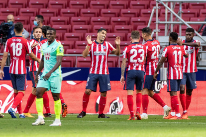 Luis Suárez (c) es felicitado por sus compañeros del Atlético de Madrid tras estrenarse como goleador.