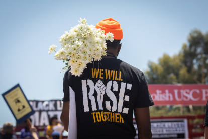 Un manifestante sostiene un ramo de flores en un Black Lives Matte.