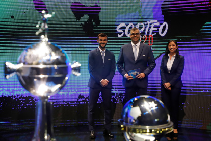 El director de competiciones de Clubes Conmebol, Frederico Nantes (c), posa junto a los trofeos de la Copa Libertadores y Sudamericana.