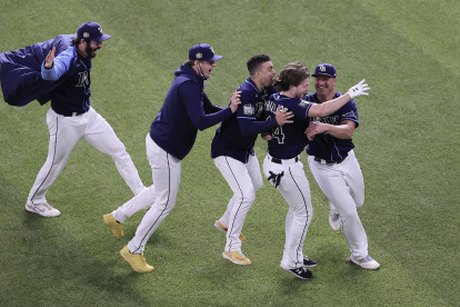 Los jugadores de los Rays de Tampa abrazan a Brett Phillips (segundo desde la derecha), autor del punto definitorio del partido de la noche del 24 de octubre.