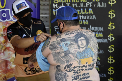 El pizzero Guillermo Rodríguez, bautizado en la iglesia maradoniana, muestra los tatuajes en su espalda que representan a la leyenda del fútbol argentino Diego Maradona, en Merlo, provincia de Buenos Aires.