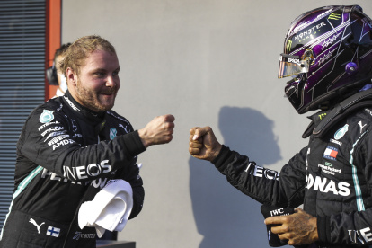 El piloto finlandés Valtteri Bottas celebra con su compañero de equipo Lewis Hamilton luego de la clasificación.