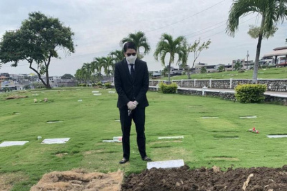 Una foto referencial de un deudo ante una tumba en un cementerio en Guayaquil.
