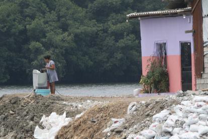 Una lavadora de ropa, junto al brazo de mar y frente al manglar que cubre la zona.