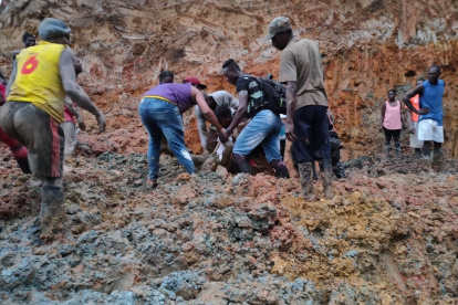 Pobladores ayudan a rescatar los cuerpos sumergidos bajo el lodo.