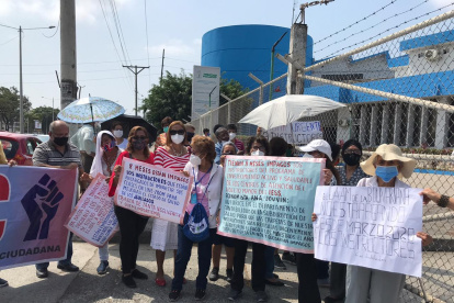 Los jubilados se concentran con pancartas, bajo el sol, para protestar.