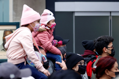 New York (United States), 26/11/2020.- Two young girls on their parents shoulders try to get a glimpse of the 94th Annual Macy"s Thanksgiving Day Parade in New York, New York, USA, 26 November 2020. Due to the COVID-19 pandemic the Manhattan parade route will be reduced to just a few blocks of giant balloons, festive floats and performers. Some of the parade will be pre taped for the television broadcast. (Estados Unidos, Nueva York) EFE/EPA/JASON SZENES