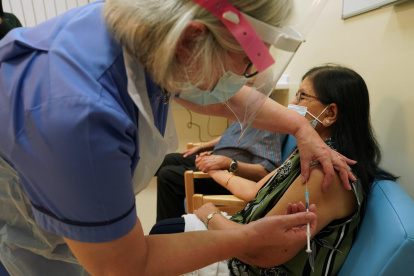 Newcastle (United Kingdom), 08/12/2020.- Ranjan Shukla, accompanied by her husband Dr Hari Shukla, receives the first of two Pfizer/BioNTech Covid-19 vaccine jabs, administered by retired nurse Suzanne Medows, at the Royal Victoria Infirmary in Newcastley, Britain, 08 December 2020. The UK started the largest immunisation programme in the country"s history. Care home workers, NHS staff and people aged 80 and over will begin receiving the jab protecting against the SARS-CoV-2 coronavirus. (Reino Unido) EFE/EPA/Owen Humphreys / POOL
