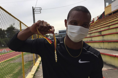 Álex Quiñónez, velocista ecuatoriano, muestra su medalla de oro tres ganar una de las pruebas.