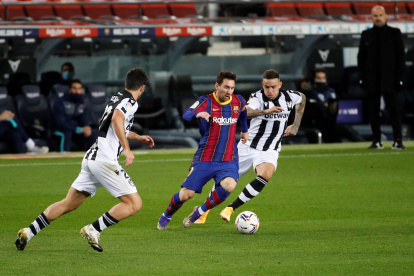 Lionel Messi, ofensivo de Barcelona, intenta eludir la marca de dos rivales del Levante.