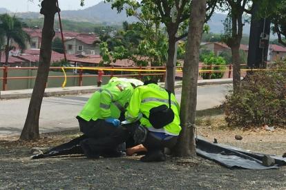 Agentes del orden verifican el cuerpo de la infrtunada y recogen indicios.