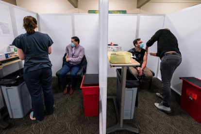 Seattle (United States), 18/12/2020.- Nurse Marcos San Martin (2-L) waits for fellow nurse Steve Rogge (2-R) gets the Pfizer-BioTech coronavirus disease (COVID-19) vaccine at vaccination clinic in a University of Washington medical center in Seattle, Washington, USA, 18 December 2020. Healthcare workers are among the first to be vaccinated throughout the United States. (Estados Unidos) EFE/EPA/STEPHEN BRASHEAR