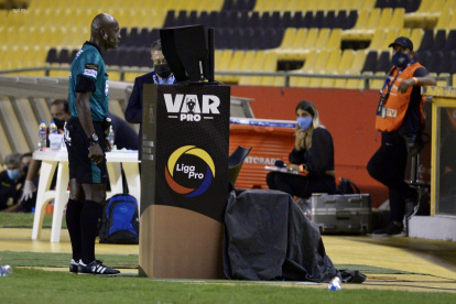 El árbitro Augusto Aragón observa la repetición de la agresión de Junior Sornoza sobre Damián Díaz