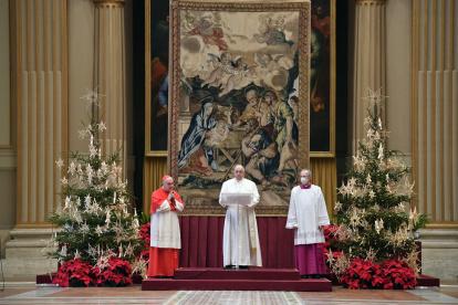Una imagen proporcionada por los medios de comunicación del Vaticano muestra al Papa Francisco (C) entrega su mensaje de Navidad Urbi et Orbi en Benedizioni.