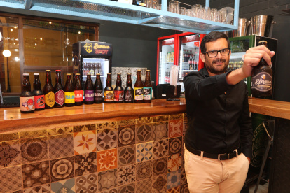 Juan Zurita, sostiene la cerveza de su marca Beerman y exhibe otras artesanales de otras marcas.
