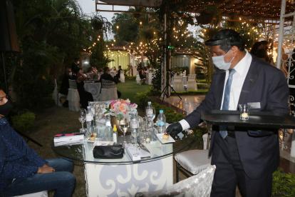 En esta fiesta se observan las mesas separadas, el bocadillo personal y cómo está la persona que está sirviendo los alimentos.