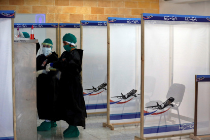 Varias personas con trajes de protección contra el coronavirus revisan el material de trabajo dentro de la zona roja en el aeropuerto internacional Jardines del Rey en Cayo Coco en Cuba.