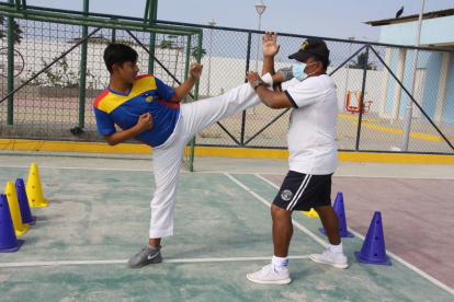 Entrenamientos. Kember Beltrán, junto a su entrenador Jorge Vargas, durante una jornada en la cancha de uso múltiple de su barrio, sitio donde improvisa sus prácticas diarias.