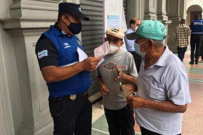 Hecho. Dos adultos mayores eran orientados por un guardia, ayer.