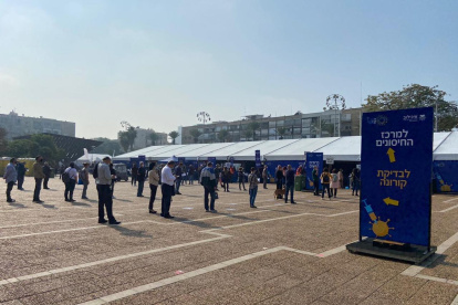 Ciudadanos hacen fila para vacunarse en un centro médico al aire libre en la ciudad de Tel Aviv