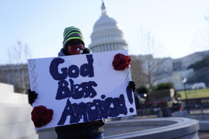 Dios bendiga a América entre los carteles que se puedan leer fuera del Capitolio.