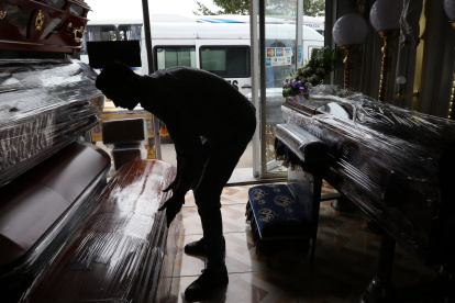 Clientes. El trabajador de una funeraria arregla los nuevos cofres adquiridos para enfrentar un repunte.