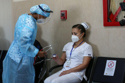 Una enfermera revisa el estado de su colega Cristina Chango recibe luego de ser vacunada contra la covid-19 en el Hospital Centinela Pablo Arturo Suárez hoy, en Quito (Ecuador).